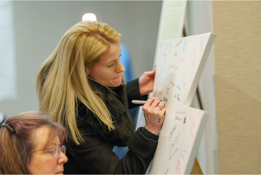 Two women sign the keystone in support of Monroe County's America250PA initiative
