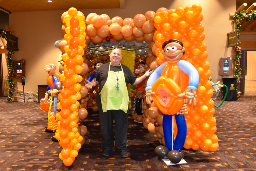 A vendor standing in front of the housing balloon display at More Front Doors: The Pocono Housing Summit