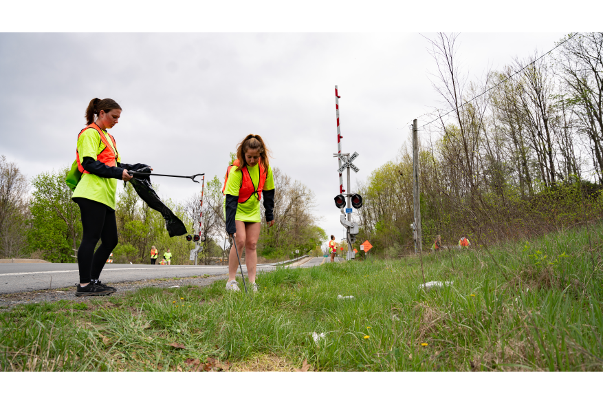 Girls picking up trash along the road