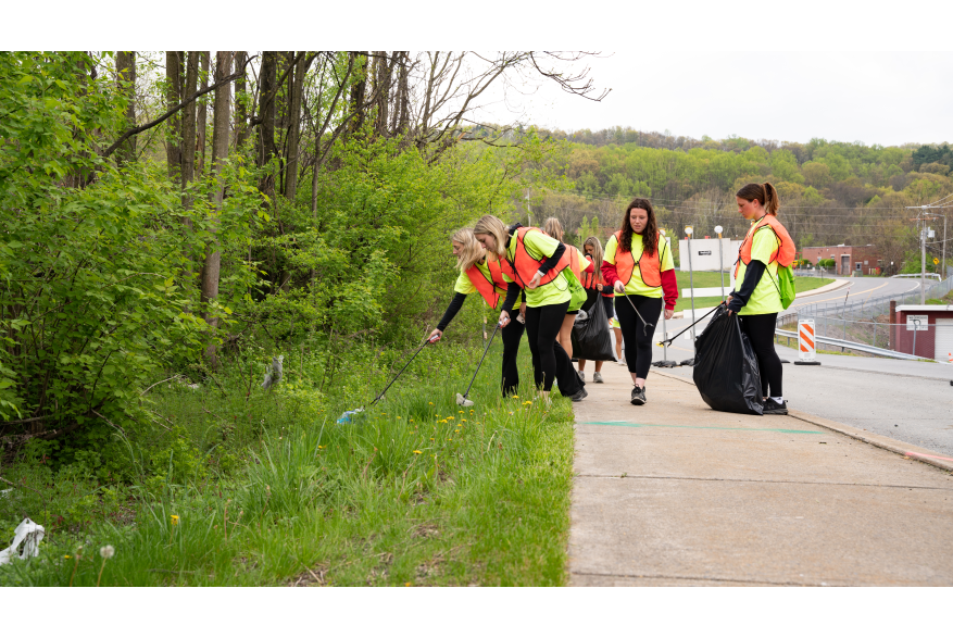 Group of students picking up trash along the road