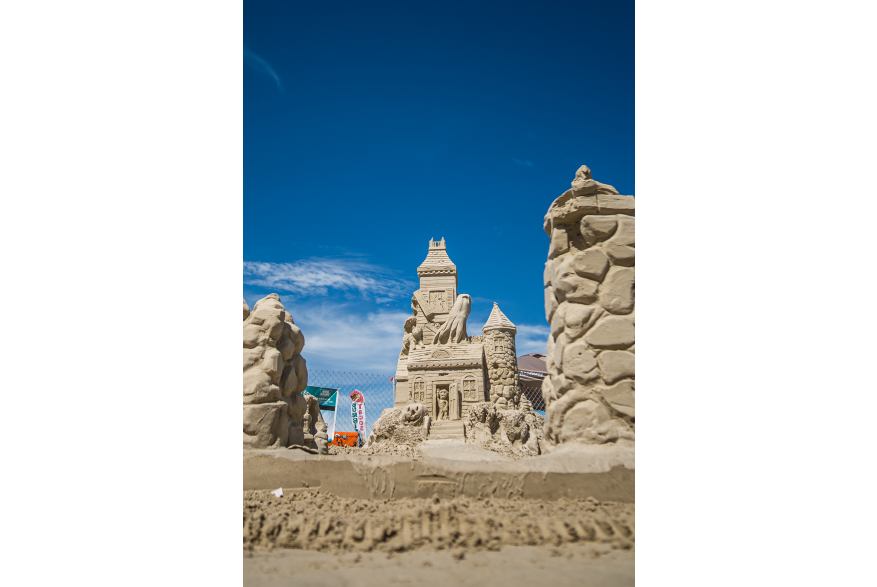 Halloween Haunted House Sand Sculpture with jack o lanterns and ghosts coming out of the top window.