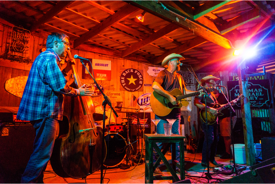 A band performs on a stage washed in orange light