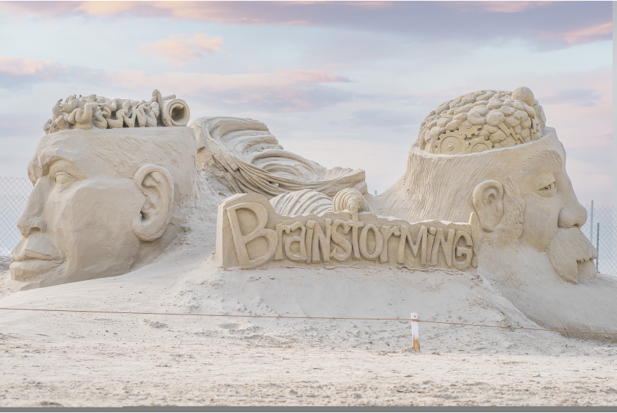 Sand sculptures of two heads with the brain exposed with a torndado in the middle.