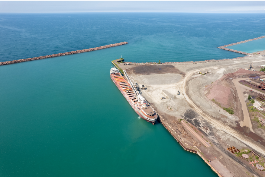 An aerial view of a port on Lake Michigan. A large ship is docked.