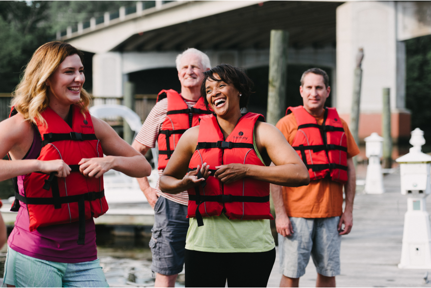 A group of people putting on life jackets