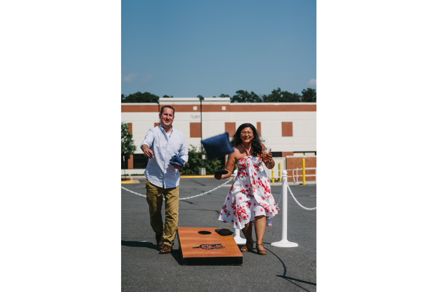 A man and a woman playing corn hole