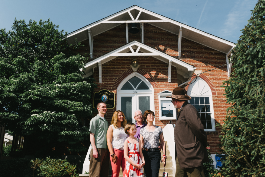 A family listening to a story in front of town hall in Occoquan