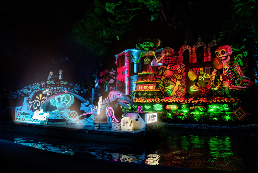 Night parade with river barge decorated with Dia de los Muertos decor