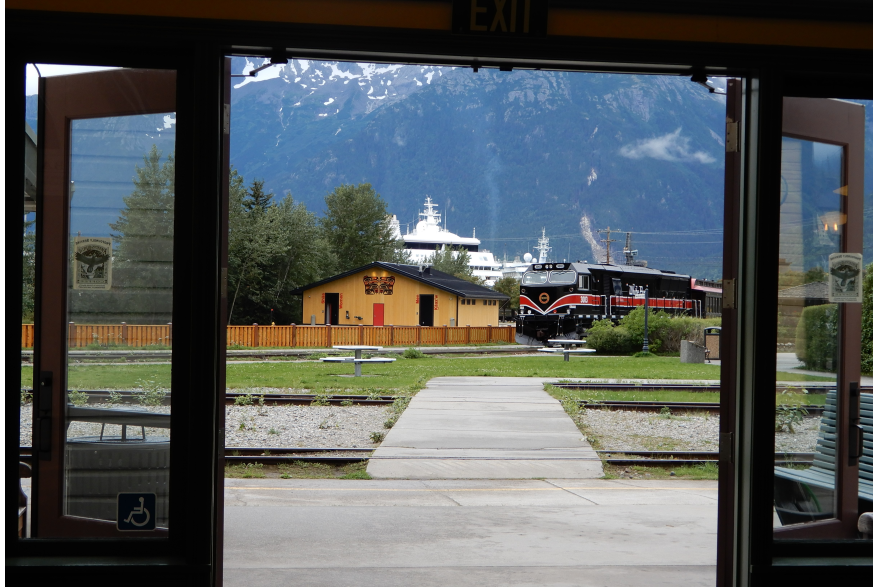 A view of the White Pass engine, Cruise ship, and Native American art. Phases of Skagway.