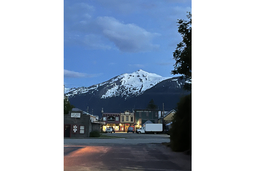 Late Alaskan night off Broadway's 5th Ave showcase gold rush era inspired false front buildings under snow covered mt harding and partly cloudy blue skies