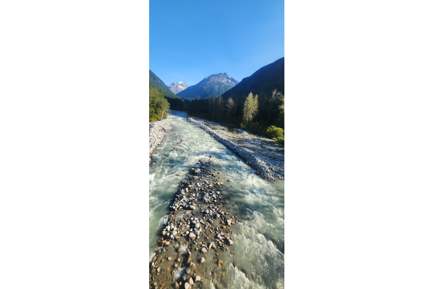 Running water surrounded by trees and mountains, taken on the White Pass Railway route on September 4, 2025.