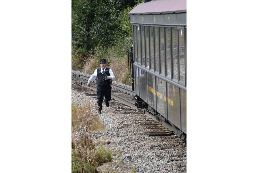 The conductor on the White Pass Rail running to catch up to the train after retrieving a cell phone from the tracks dropped by a passenger on a previous train. He made it too!