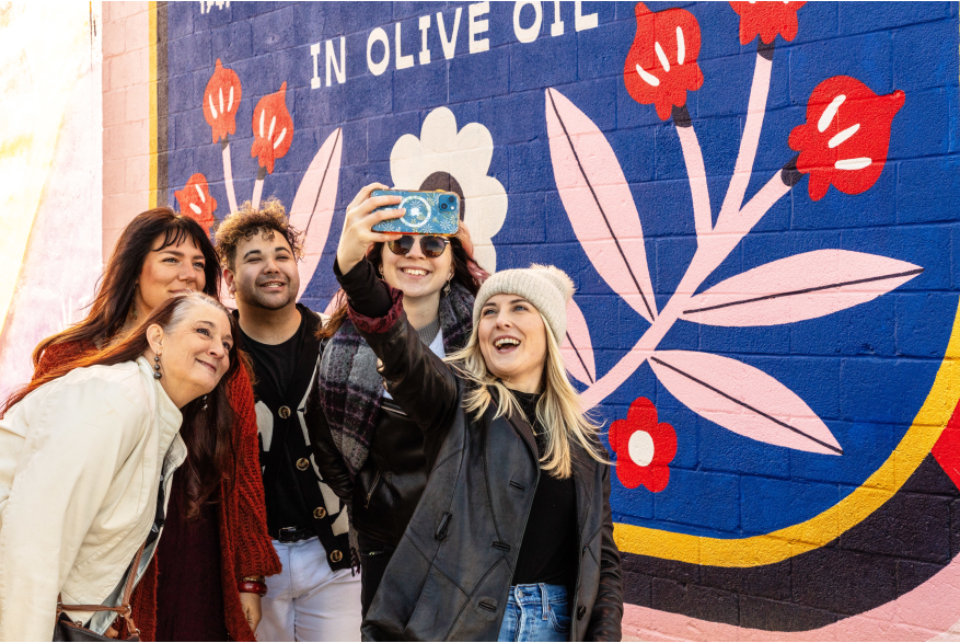 friends taking a selfie in front of a mural at Mural Park in the Royal Square District of Downtown York