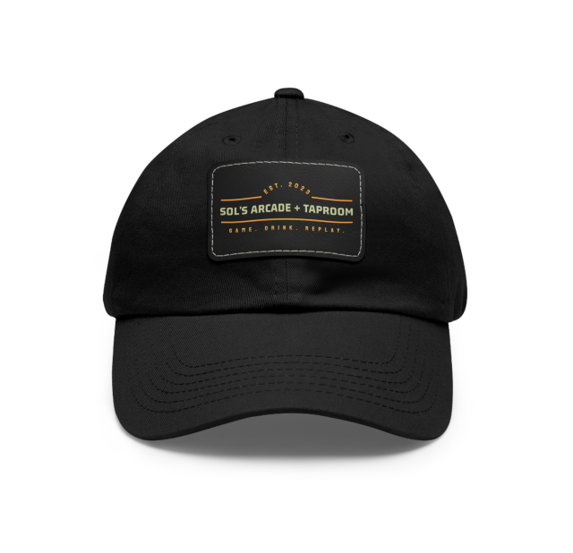 A black baseball cap featuring a stitched rectangular patch with the Sol’s Arcade + Taproom logo and the tagline “Game. Drink. Replay.” displayed on the front.