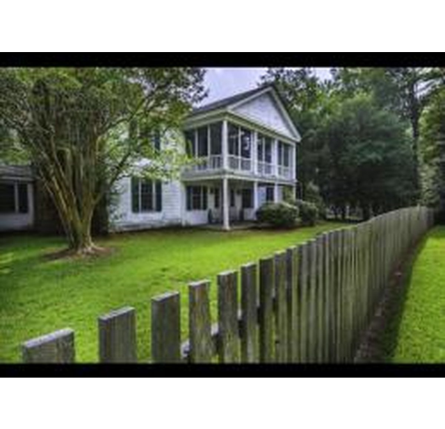 James Rockefeller House at Carvers Creek State Park, a historic white home with a porch and wooden fence surrounded by trees.
