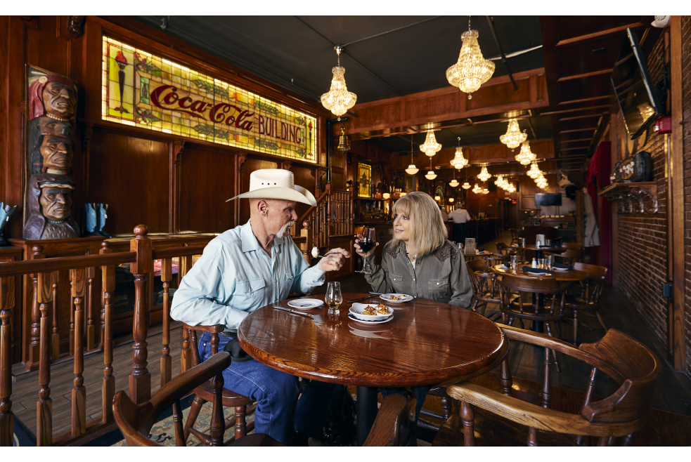 Couple enjoying wine and appetizers at McClintock Saloon & Chop House in OKC's Stockyards City