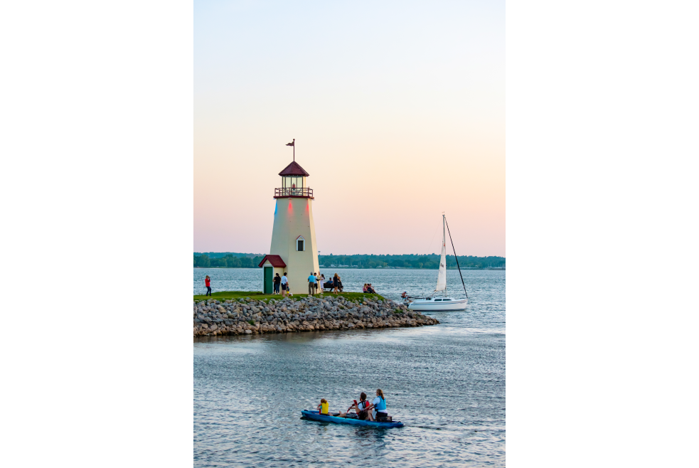 People boating and kayaking on Lake Hefner with the Lake Hefner lighthouse in the background