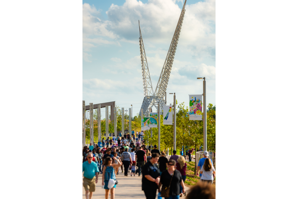 Crowd enjoying Oklahoma City's Scissortail Park with "Skydance Bridge" in the background
