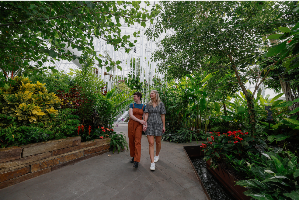 Couple walking through the Myriad Botanical Gardens' Crystal Bridge