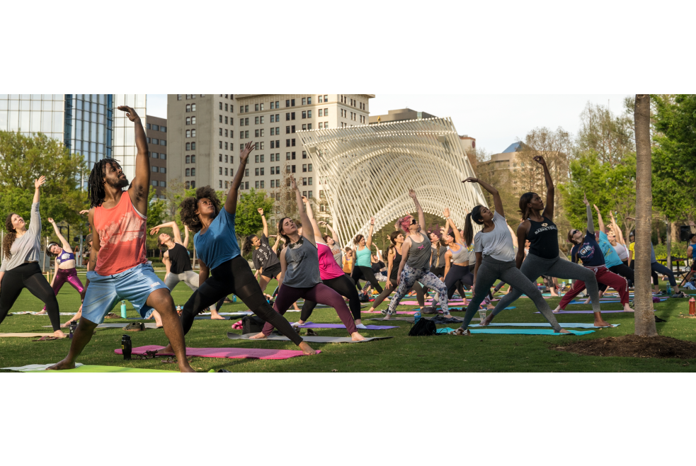 Large group practicing yoga on the Myriad Gardens lawn