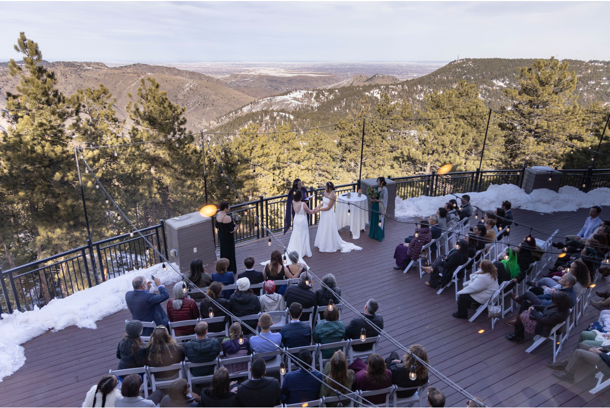 View from above of wedding ceremony on the outdoor patio in winter at Mt Vernon Canyon Club for a wedding ceremony the foothills mountains are in the background