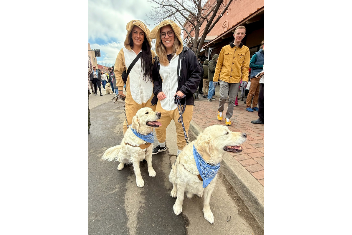 Two people dressed at golden retrievers and their dogs at Goldens in Golden CO 2025