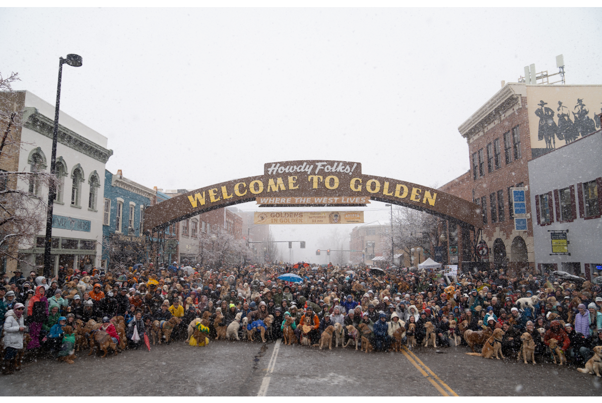 Group photo under Welcome to Golden arch for Goldens in Golden event