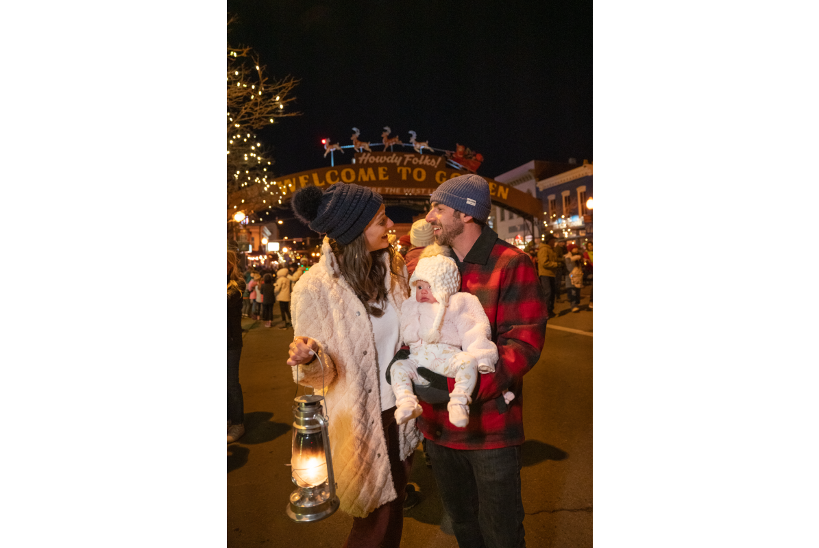 A young family enjoying the Candlelight Walk in downtown Golden