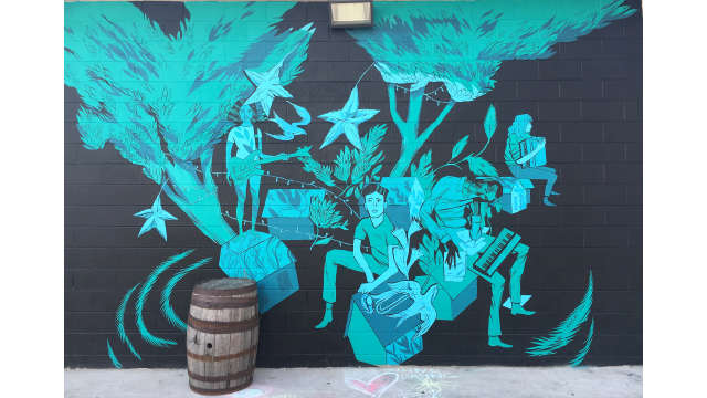 A black and blue mural by Anthony Wislar on the side of Creature Comforts Brewing