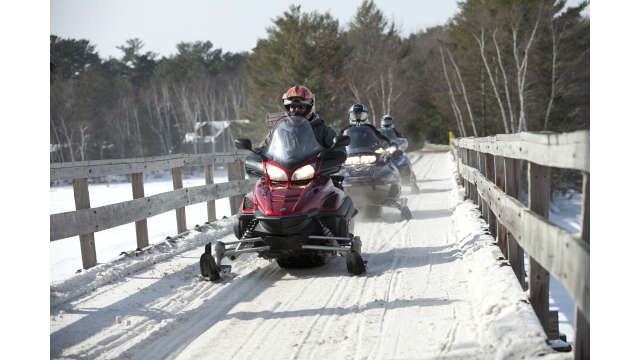 A group heads into the Minocqua wilderness on their snowmobiles.