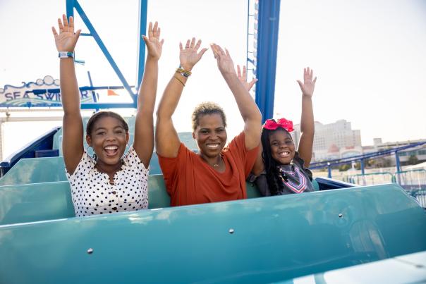 African American family of three on amusement park ride at Paradise Pier Fun Park