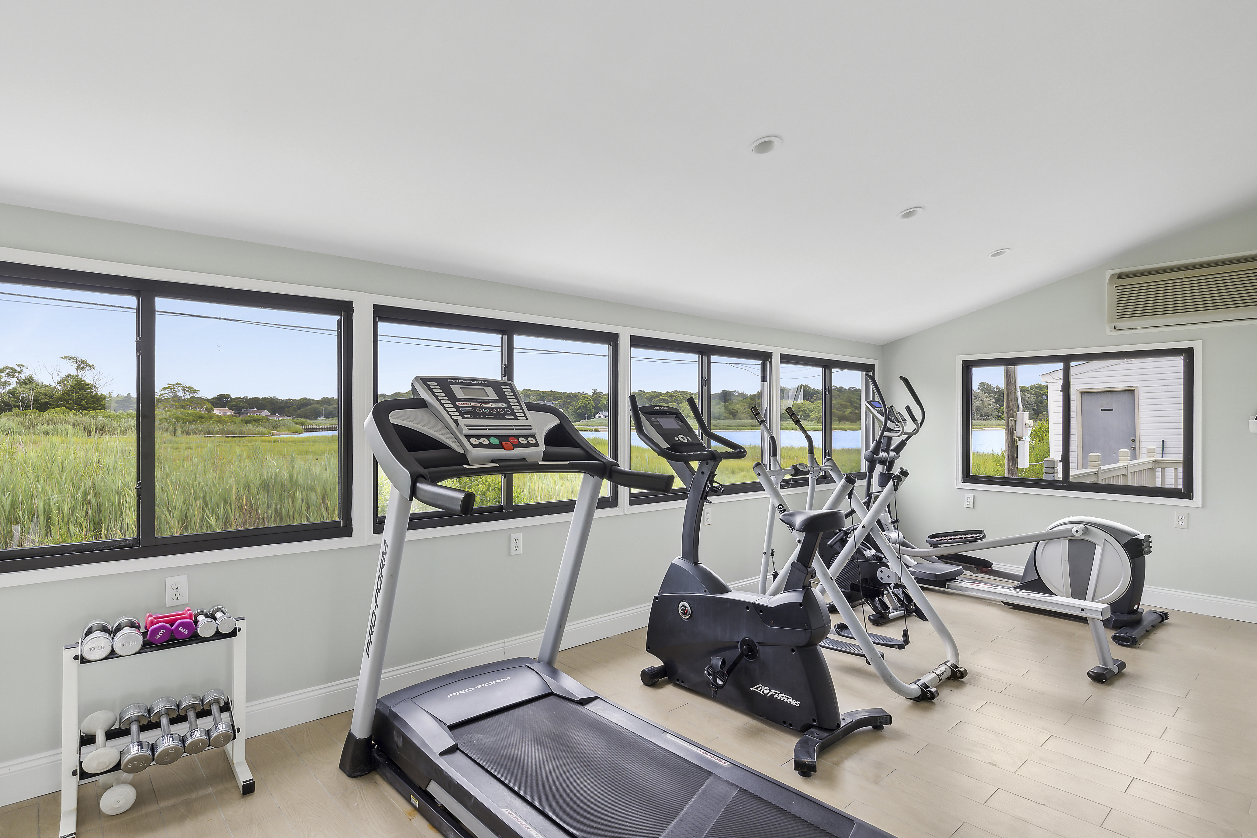 Amenities - Fitness Center - Our fitness center, off of the Clubhouse main area, features five (5) machines and various weights. Take in the North facing views of Tiana Bay while getting a quick workout in!