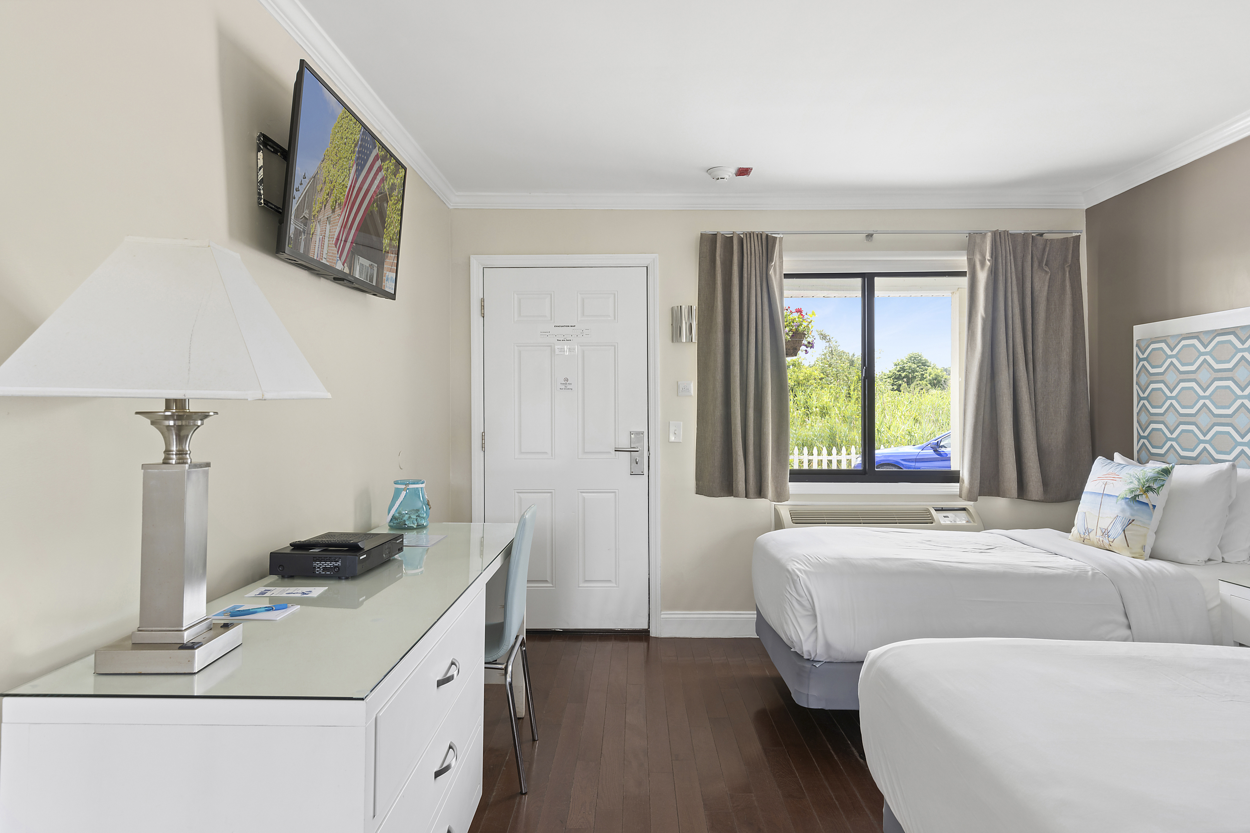 Room Class - Waterview Twin - The Waterview Twin rooms are located on the ground level of our two-story building, situated closer to Tiana Bay providing more immediate access to our various waterside amenities. The Waterview Twin rooms feature two (2) twin-sized beds, a kitchenette, and a flat-screen TV. There are two (2) Waterview Twin rooms on our premises.