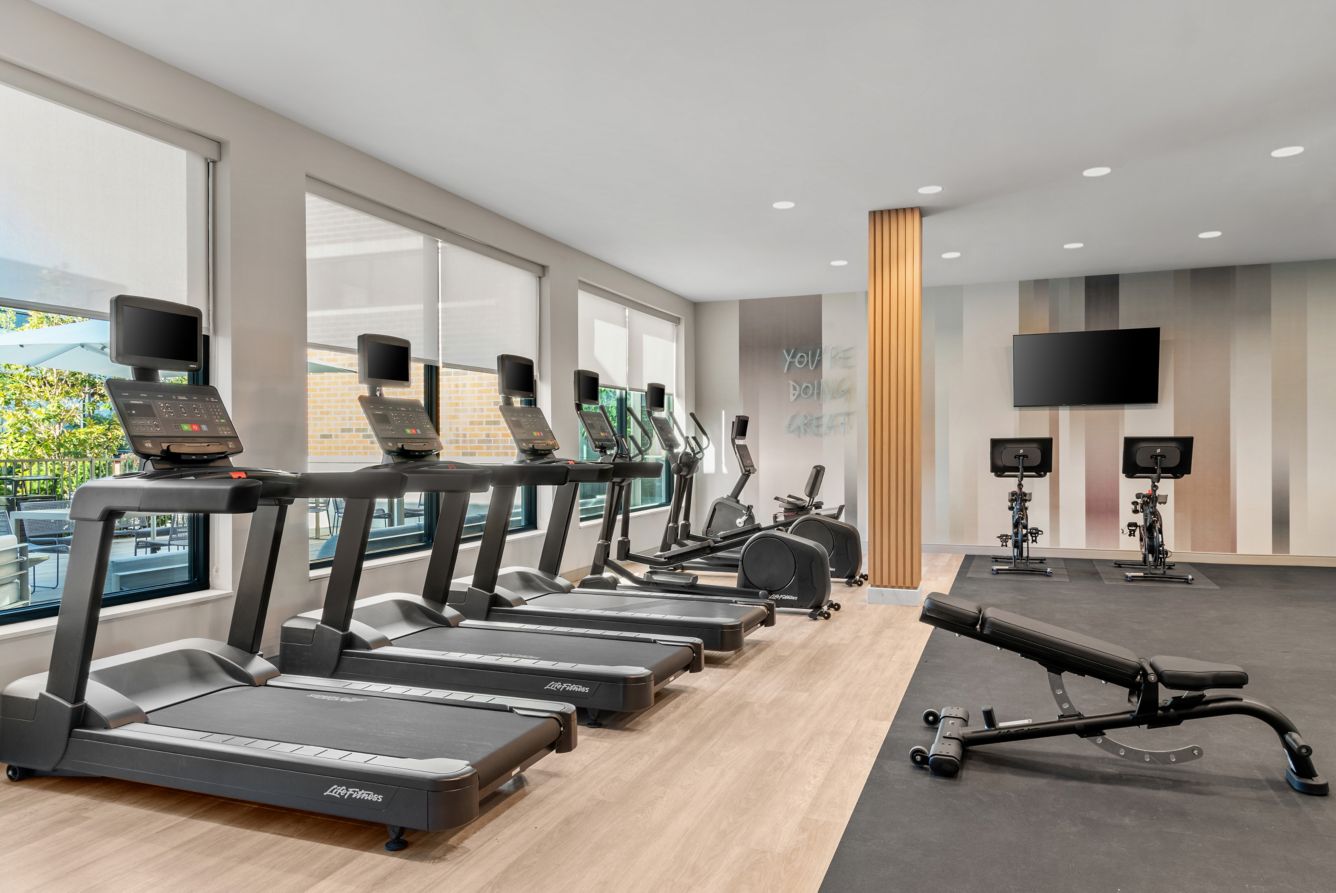 Fitness Center - Our fitness center features a bright, open layout with large windows overlooking the Courtyard, state-of-the-art cardio machines, and a designated area for strength training. This energizing environment is perfect for maintaining your wellness routine while on the road.