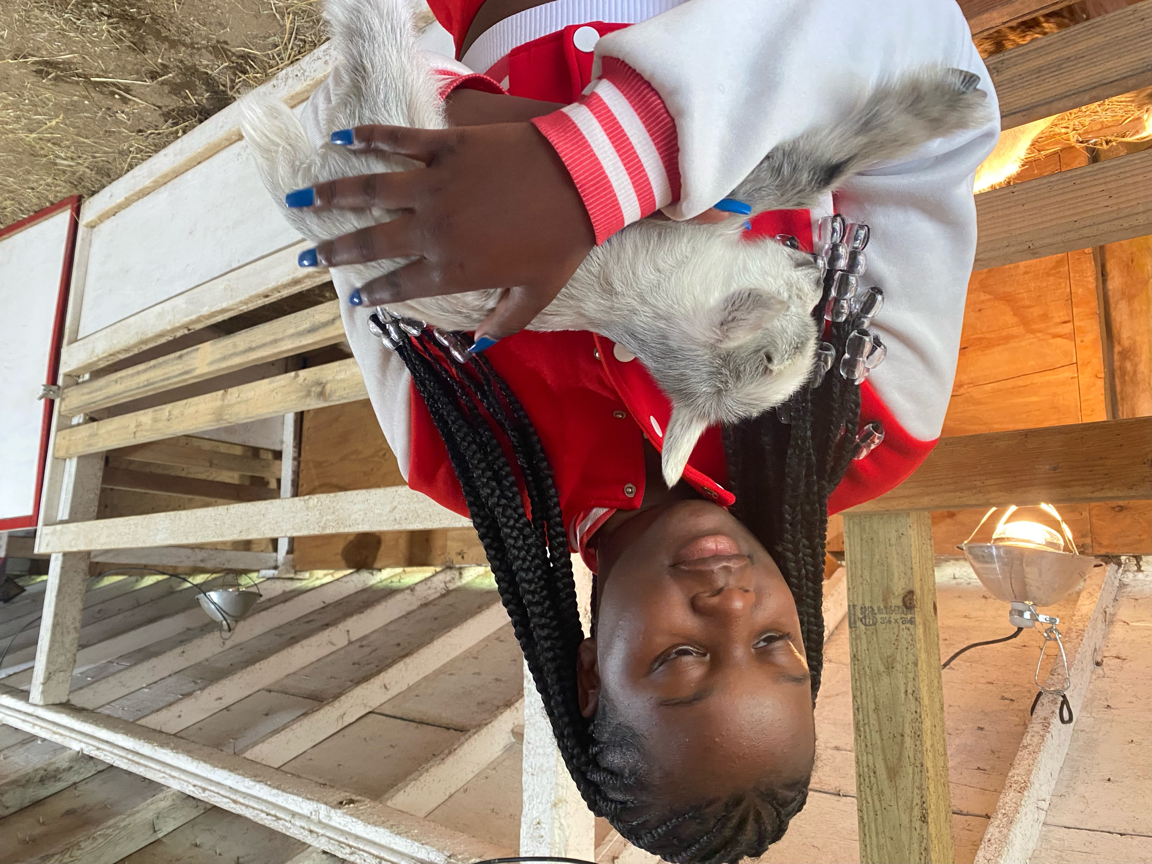 Intern Alexandra Fulford holds newborn kid goat 4/22