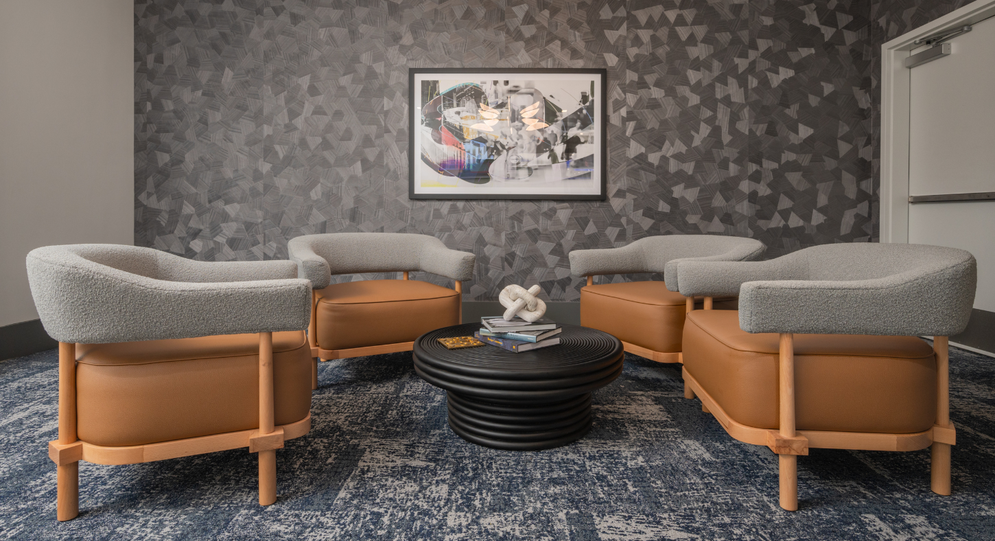 Common area at The Core featuring three leather seats and a coffee table