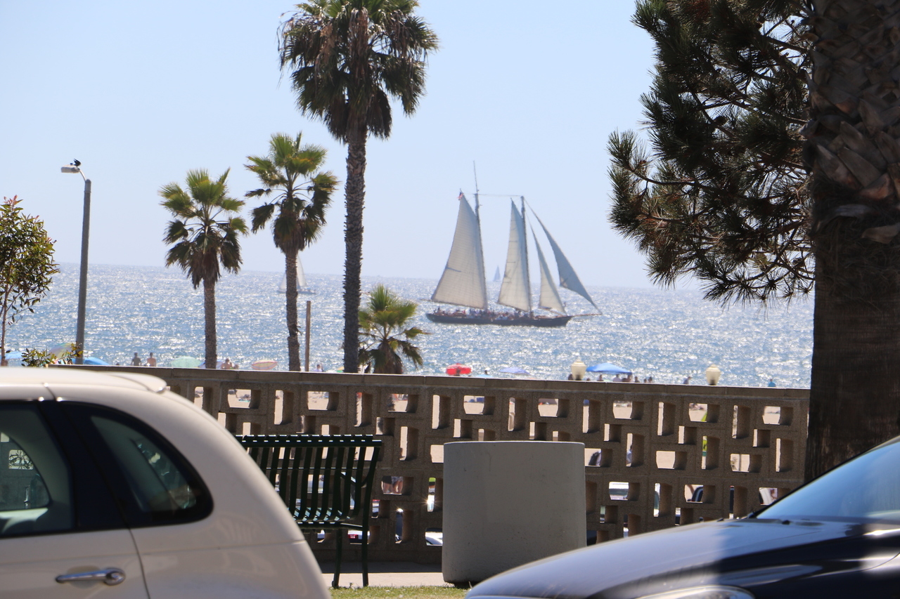 Many sail boats in the water in front of the house.