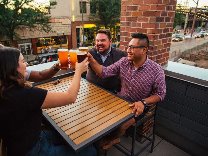 Friends clinking beer glasses at brewery