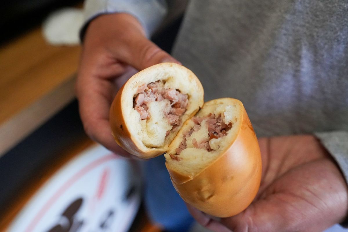 A Venezuelan ham cachito torn open to show the chopped ham filling at Trigo’s Bakery in Orem
