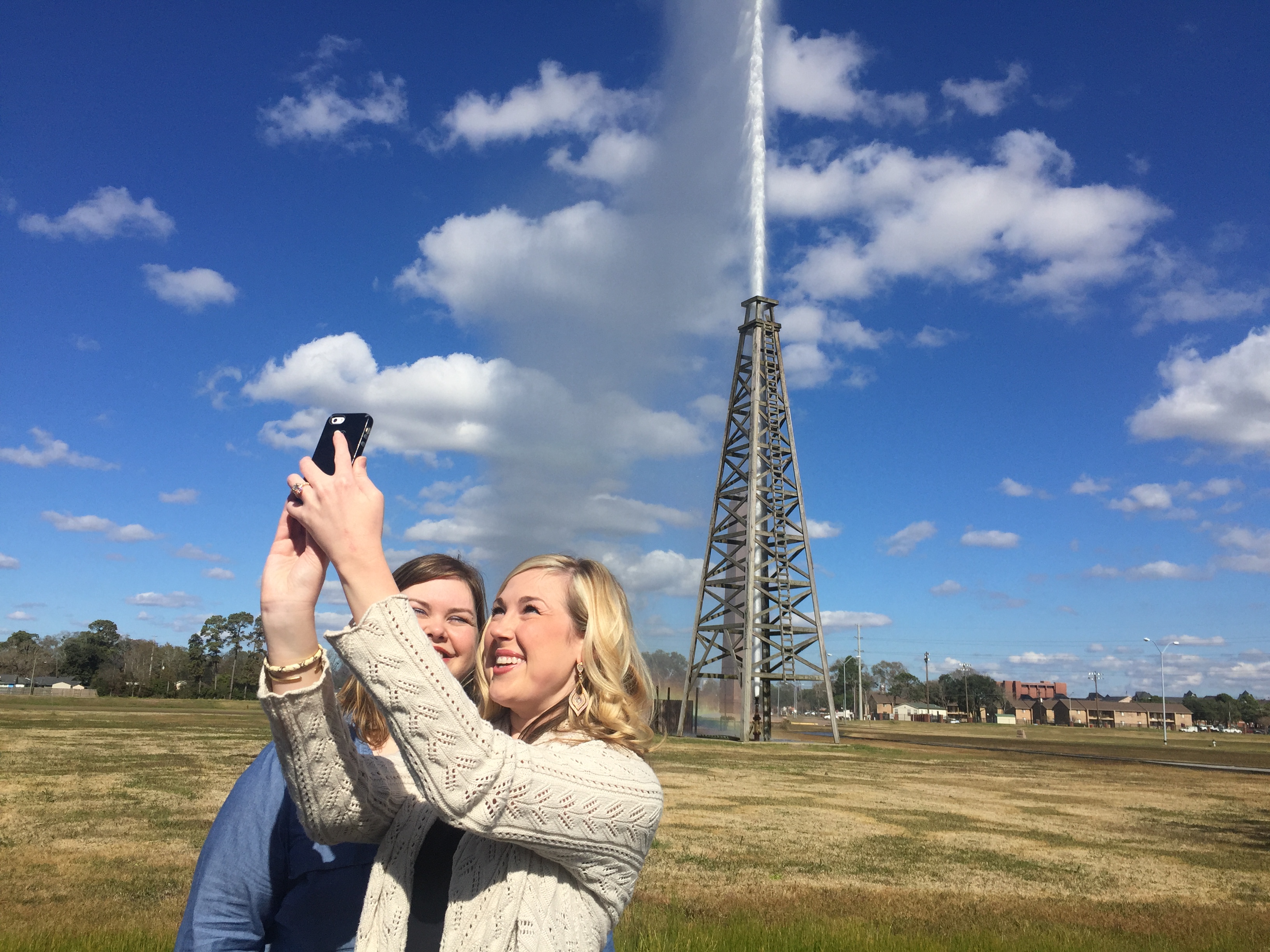 Visitors take a selfie at Spindletop as the gusher blows
