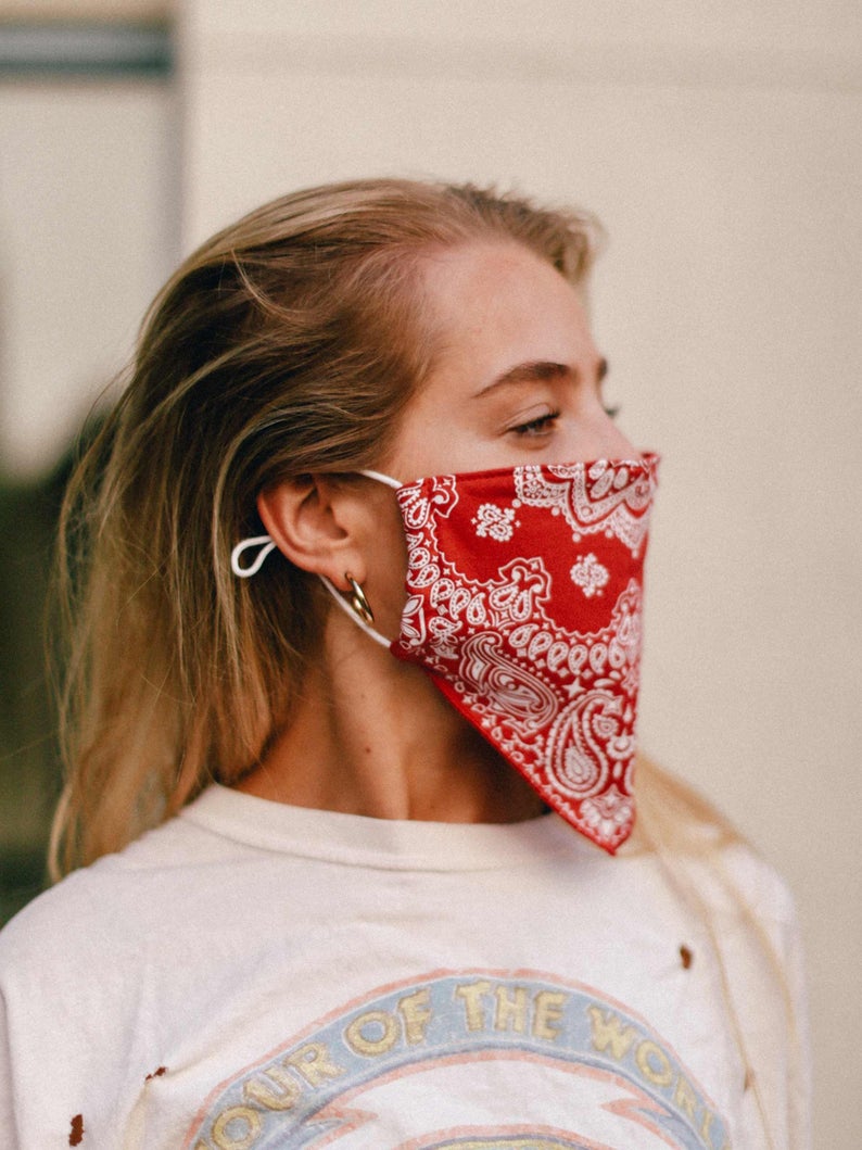 Woman models a red bandana-style medical mask.