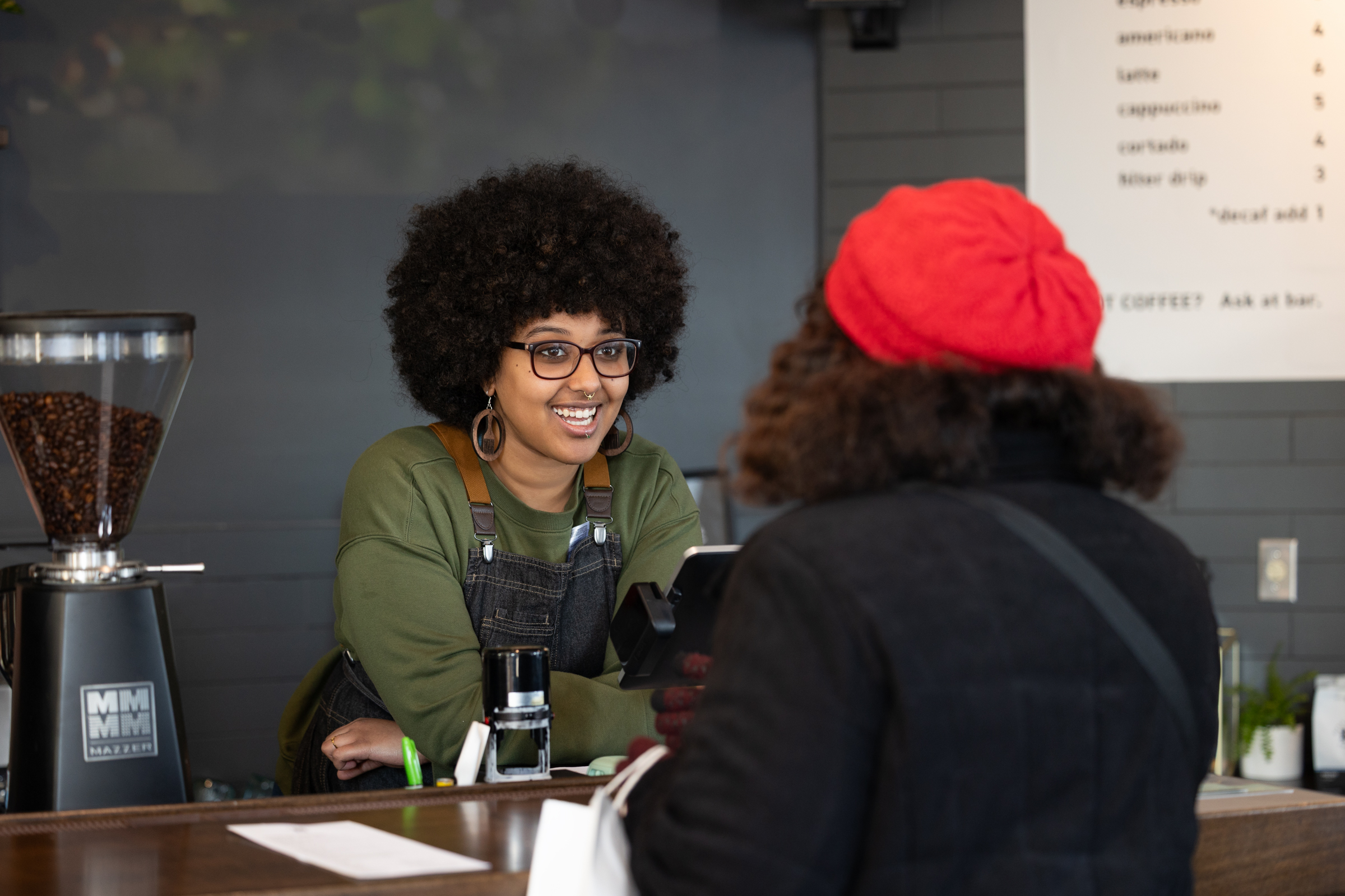 Worker at Black Kahawa Coffee talking to customer