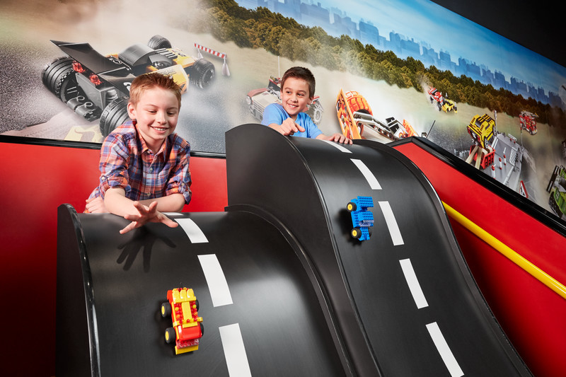 Two boys racing cars down test track in LEGO Racers: Build & Test zone