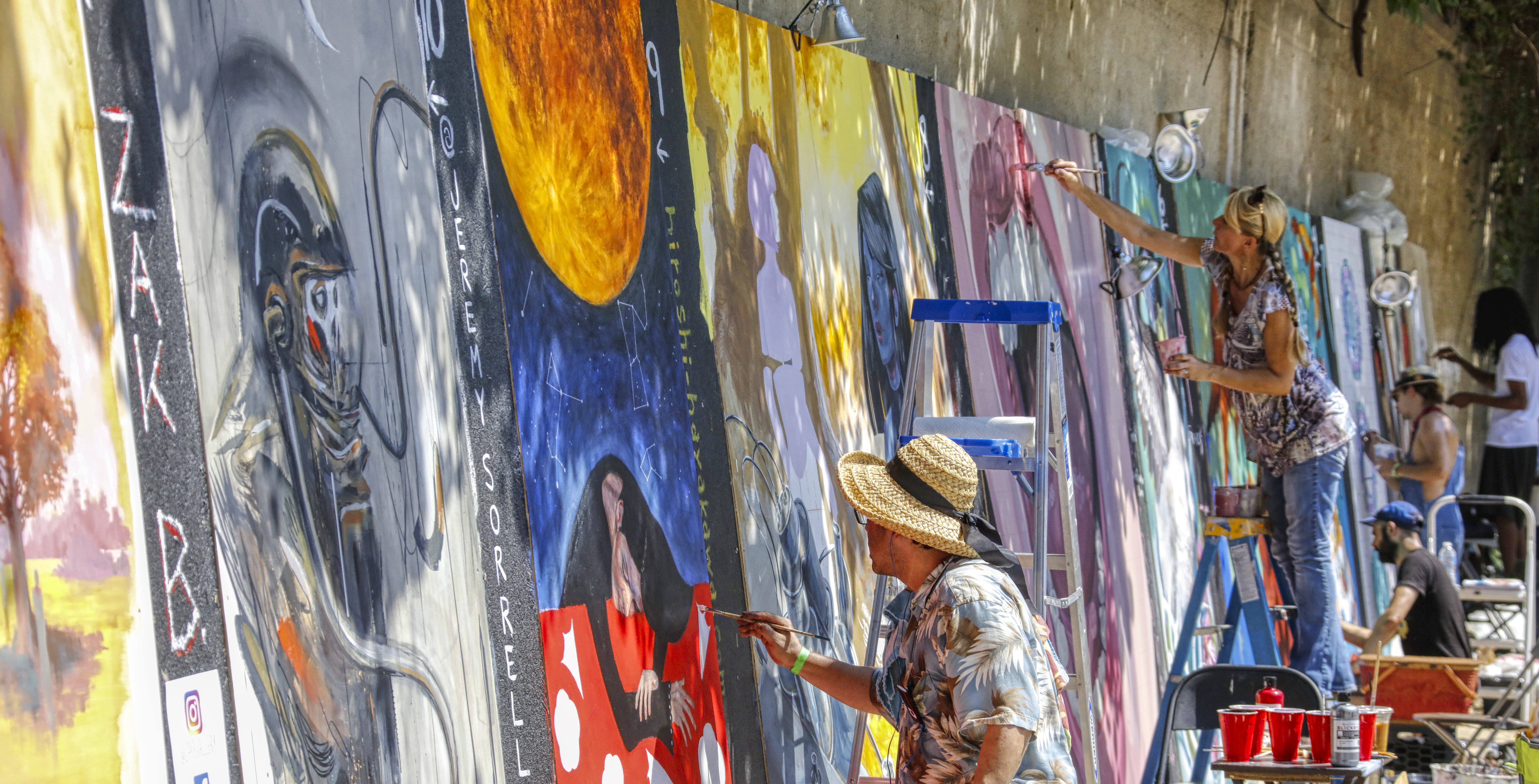 Live mural painters with vibrant artwork at Urban Scrawl in Franklinton