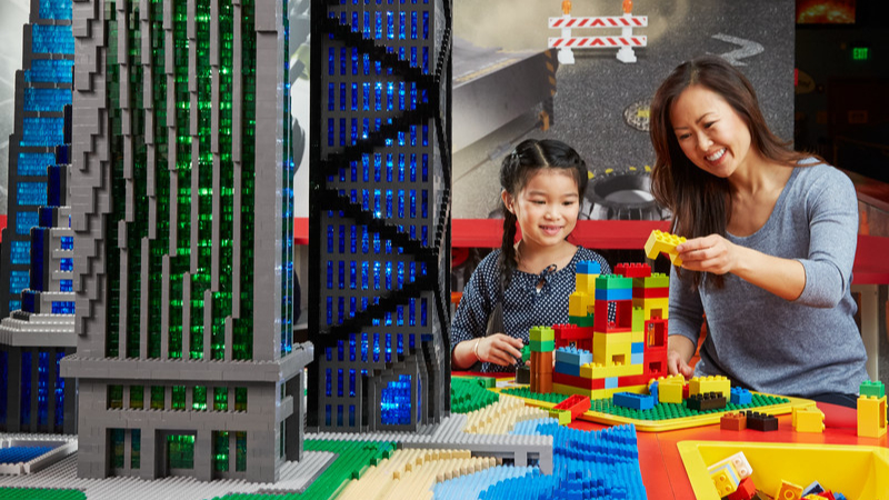 Mother and daughter building a LEGO tower to test its strength against earthquake tables
