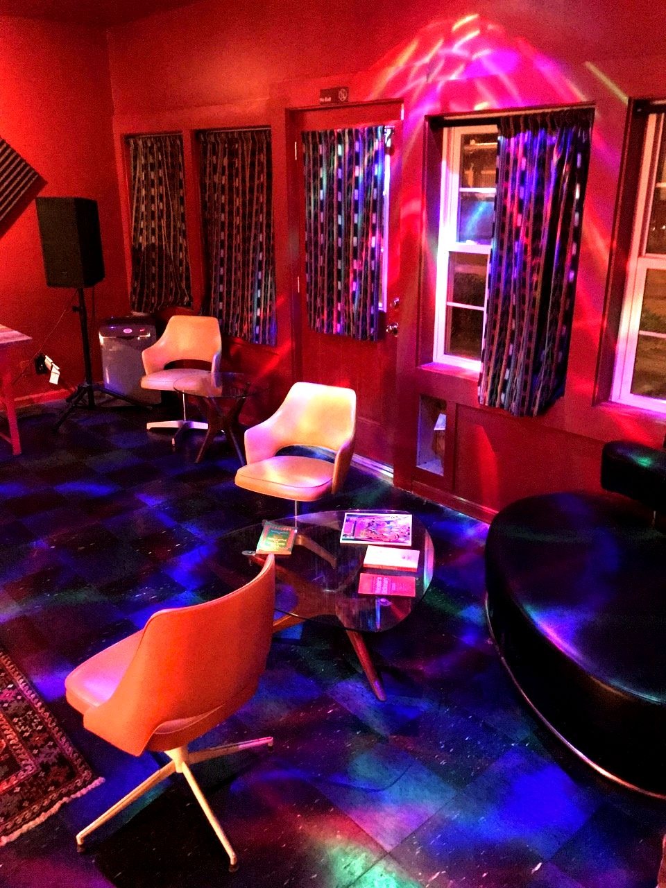 View of retro furniture and psychedelic, colorful lights inside The Oracle bar