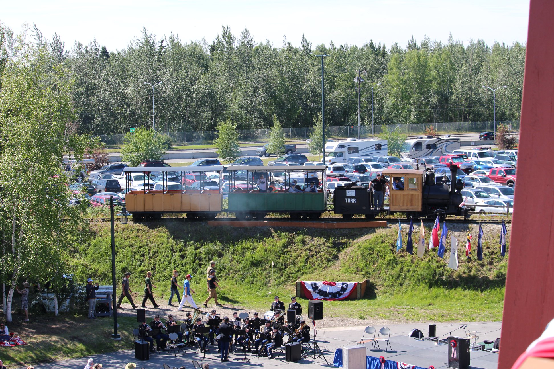 Small passenger train at a community park with crowd in foreground