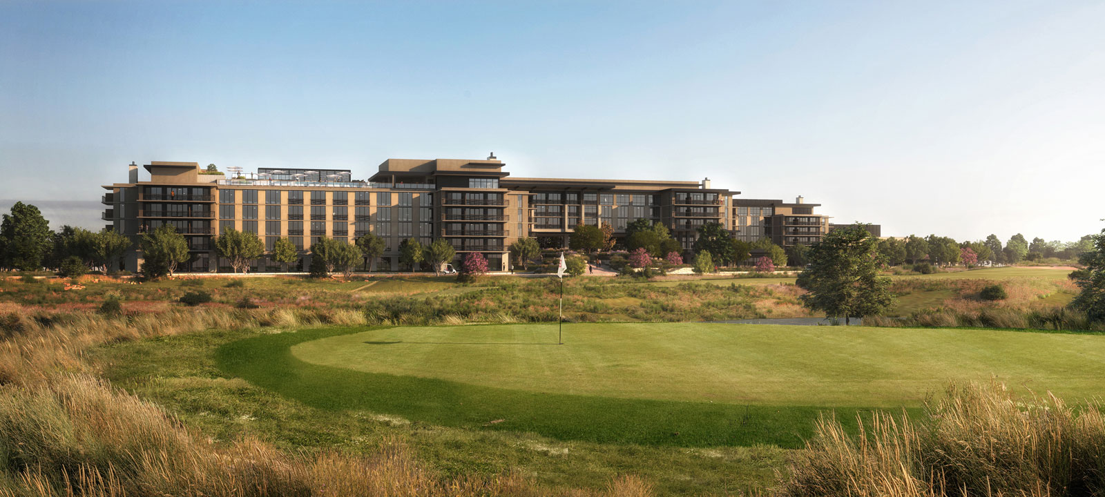 The beautiful Omni PGA Frisco Resort stands in the background of  a golf green in Frisco, Texas.