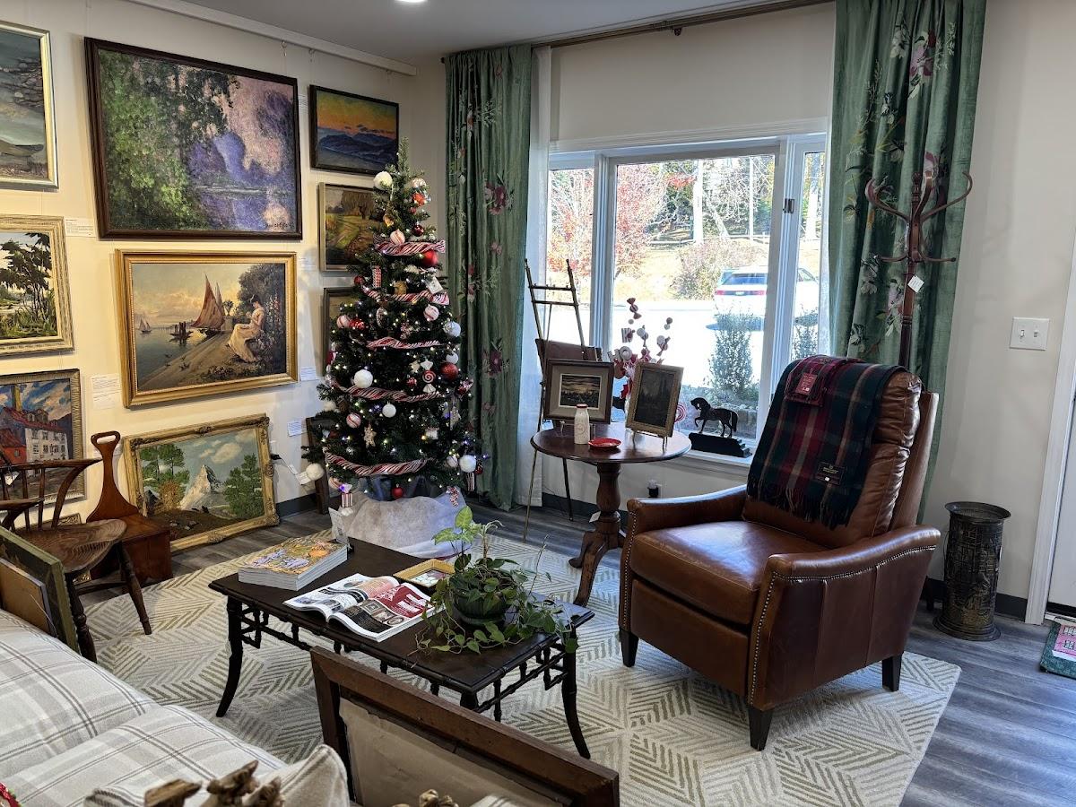 Landscape paintings hung salon style in a Highlands gallery