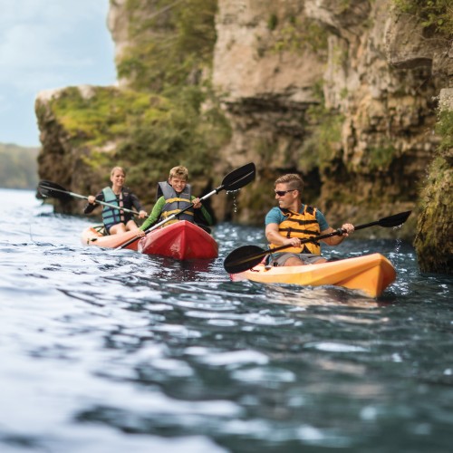 Kayakers paddling along a rocky shoreline in Shores & Islands Ohio